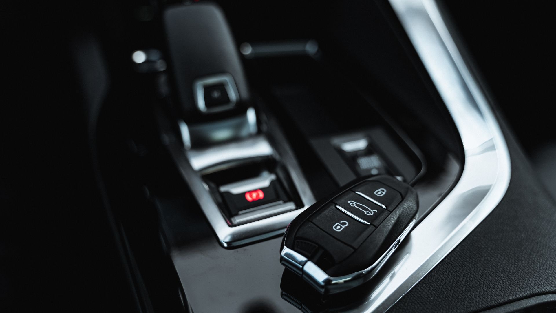 Modern car key fob and start button on sleek vehicle interior console