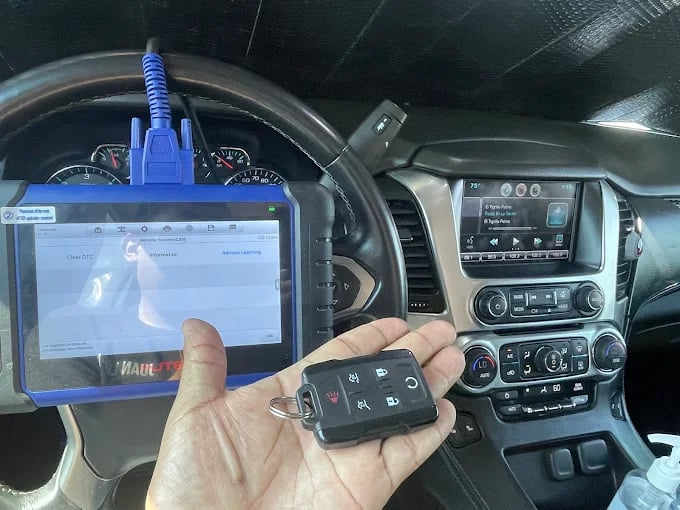 Diagnostic tool and car key inside vehicle dashboard during vehicle scan