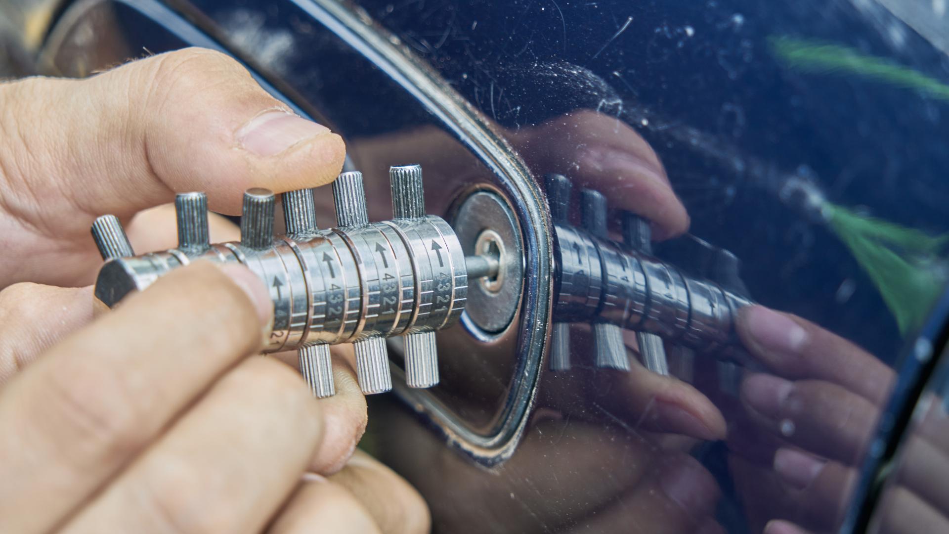 Automotive locksmith working on a car door lock cylinder