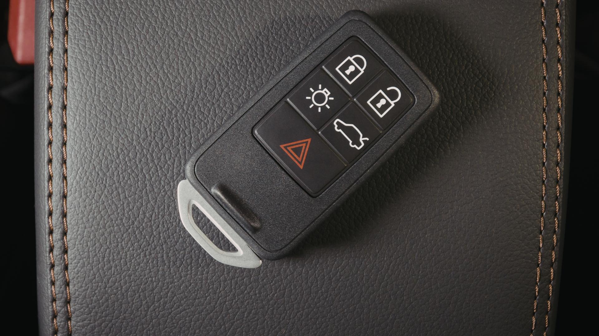 Replacement key fob being handed to customer beside vehicle